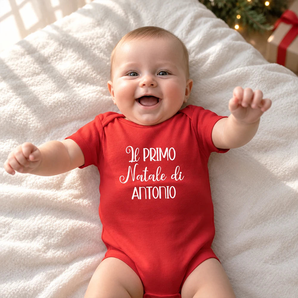 Neonato con body rosso personalizzato con la scritta Il primo Natale di Antonio