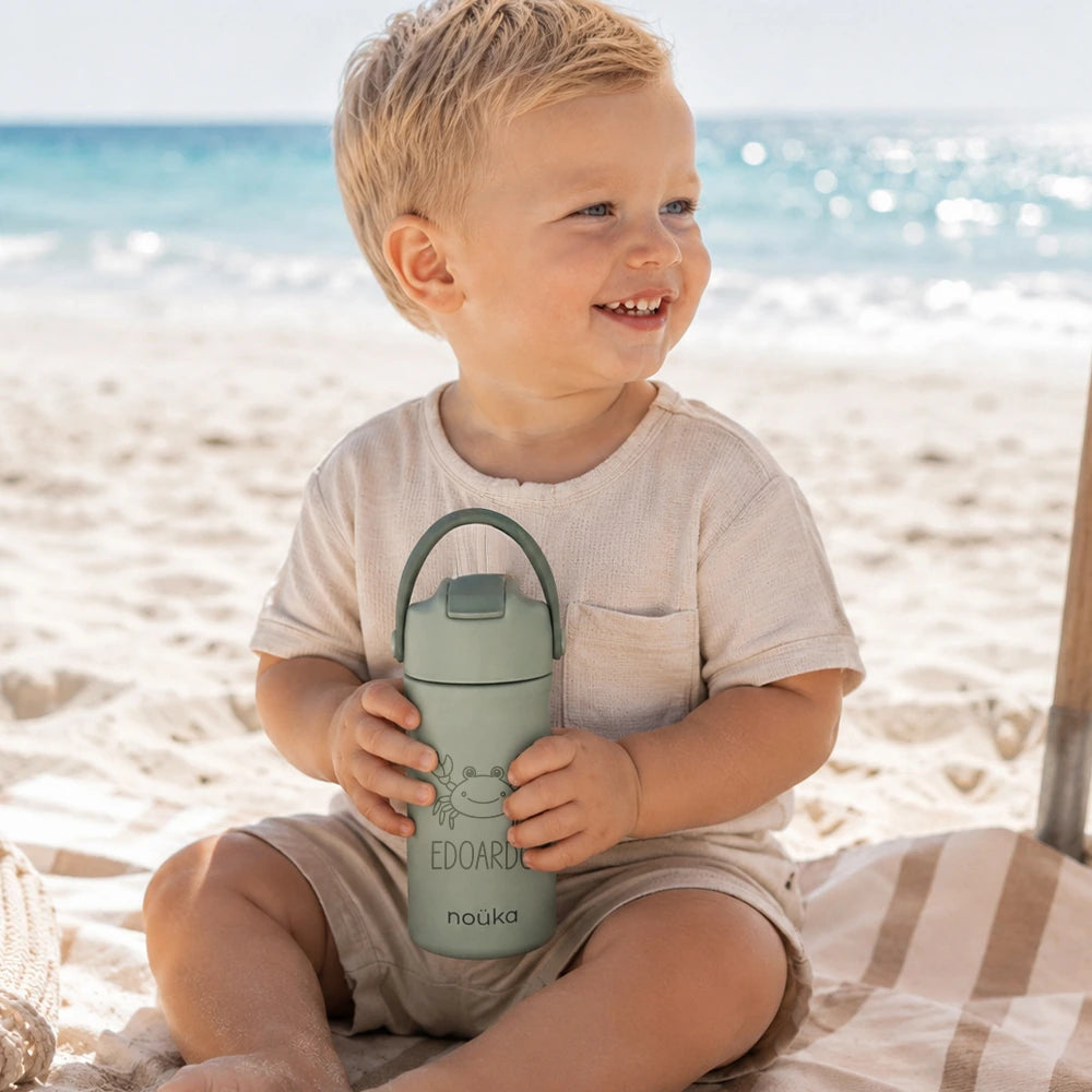 Bambino al mare con borraccia personalizzata verde Nouka con nome Edoardo