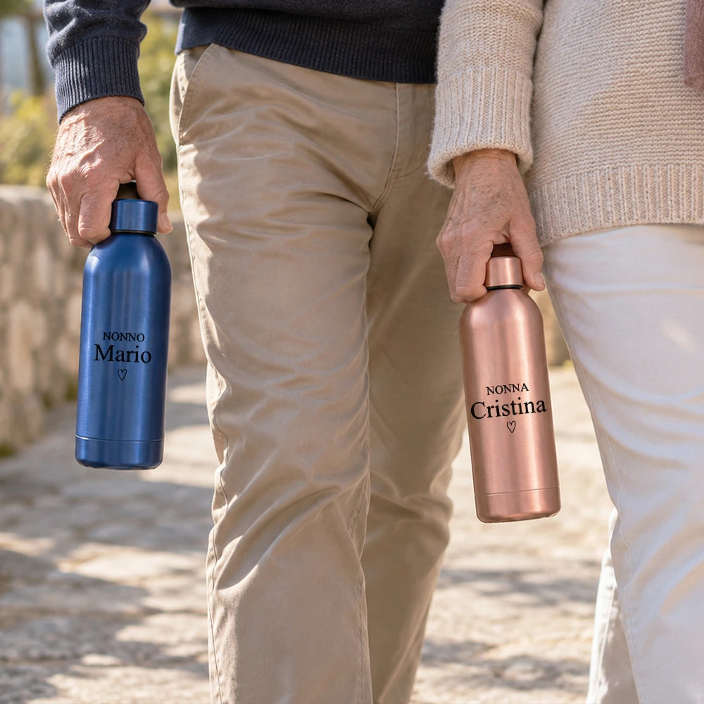 Coppia di nonni in passeggiata con borracce personalizzate blu e rosa gold con nome