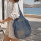 Borsa a rete personalizzabile in cotone biologico con frase sul pannello frontale.
