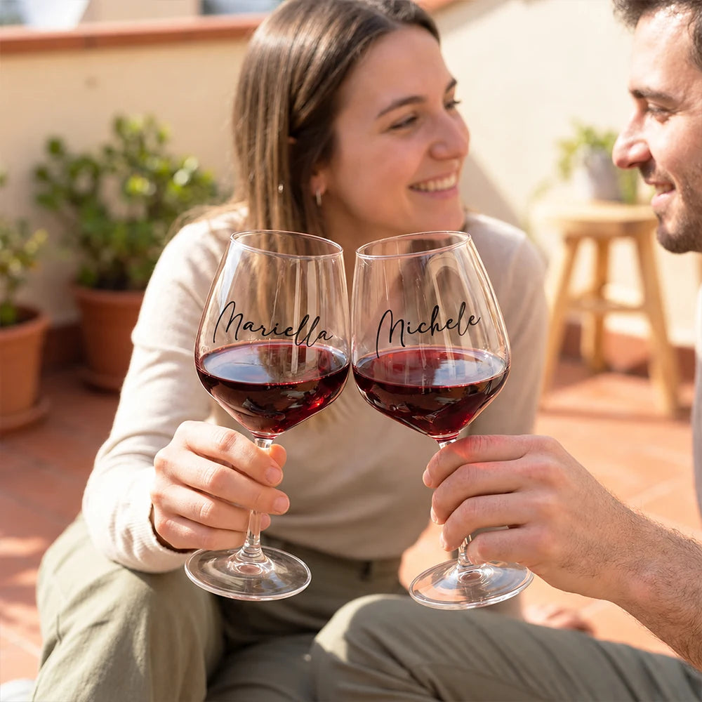 Brindisi con calici da vino personalizzati con i nomi Mariella e Michele in terrazza