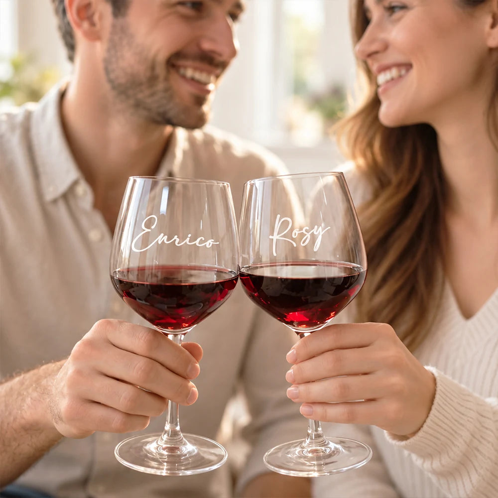Coppia sorridente con calici da vino rosso personalizzati con i nomi Enrico e Rosy