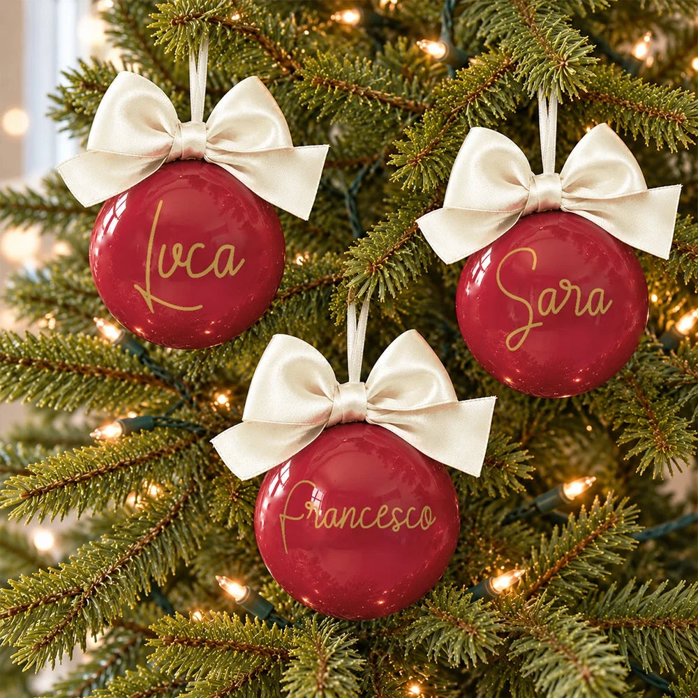 Set famiglia con tre sfere di Natale rosse personalizzate con nome e fiocco avorio sull’albero