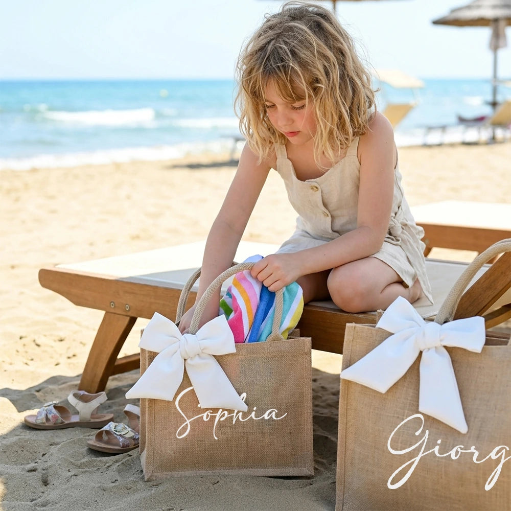 Bambina con borsa juta su spiaggia